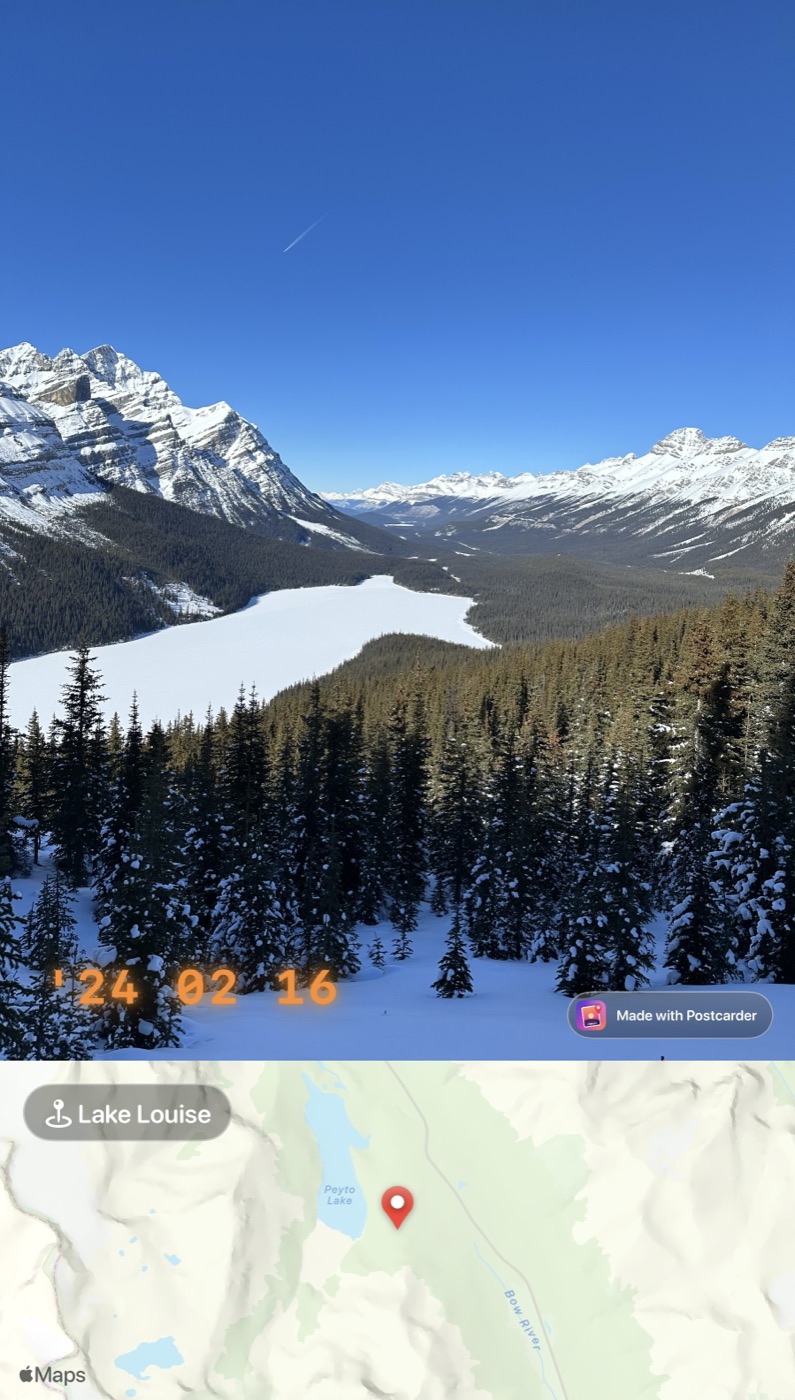 A frozen lake below snowy peaks, with an orange film-camera date stamp and a map strip underneath labelled Banff National Park