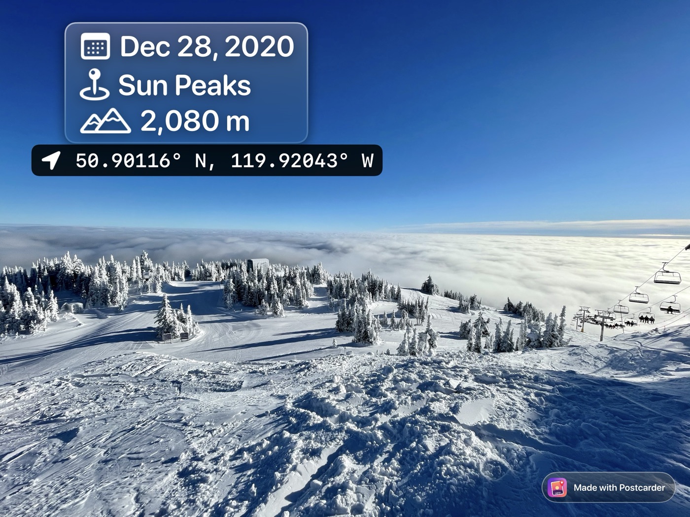 A ski run above a sea of cloud, with a glass label reading Dec 28 2020, Sun Peaks, 2,080 m, and GPS coordinates